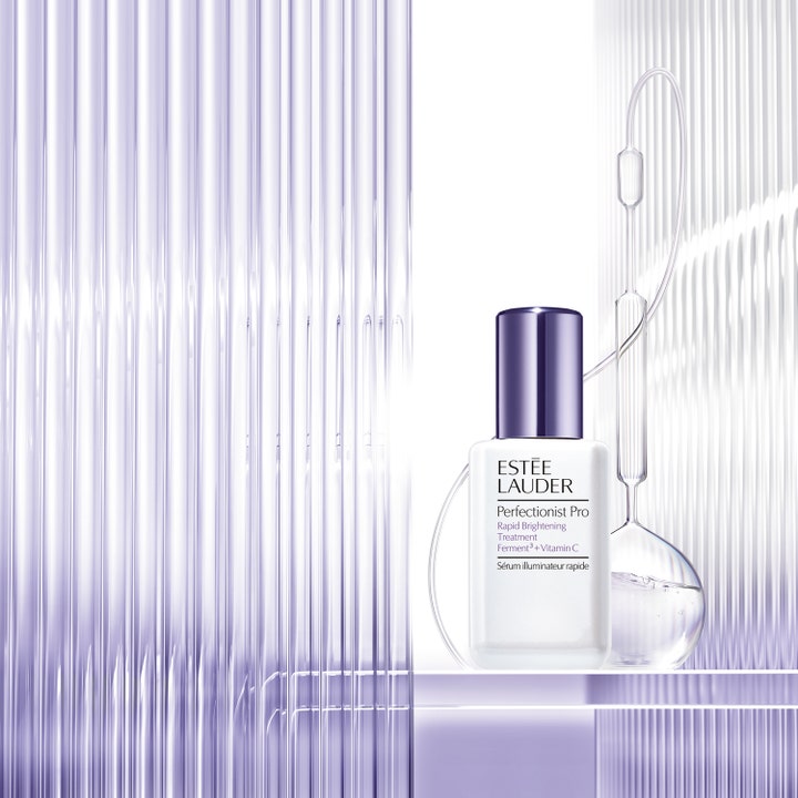 Estée Lauder Perfectionist Pro 50 ml vitamin C serum som gir glød i hvit flaske med lilla kork i laboratoriemiljø