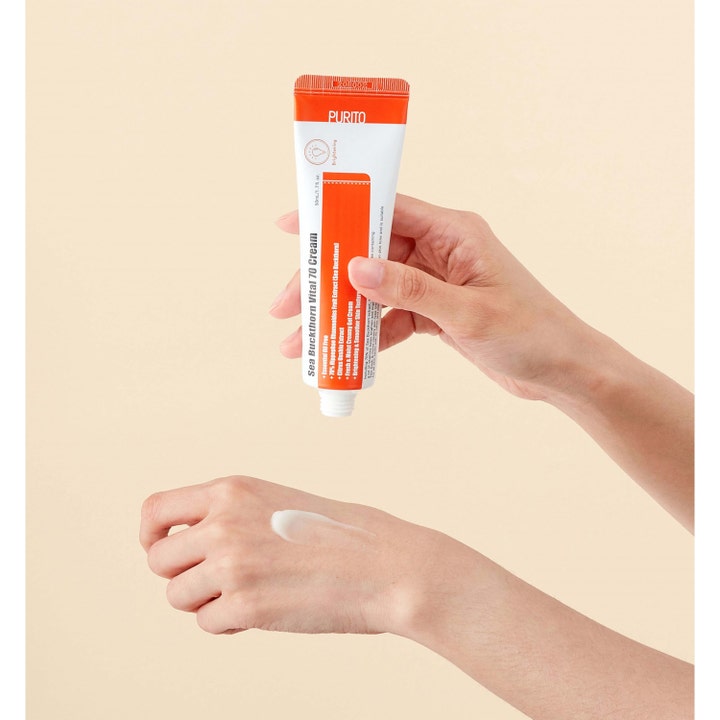 Purito Sea Buckthorn Vital 70 Cream 50 ml opplysende ansiktskrem i hvit og oransje tube med hvit kremtekstur på en hånd