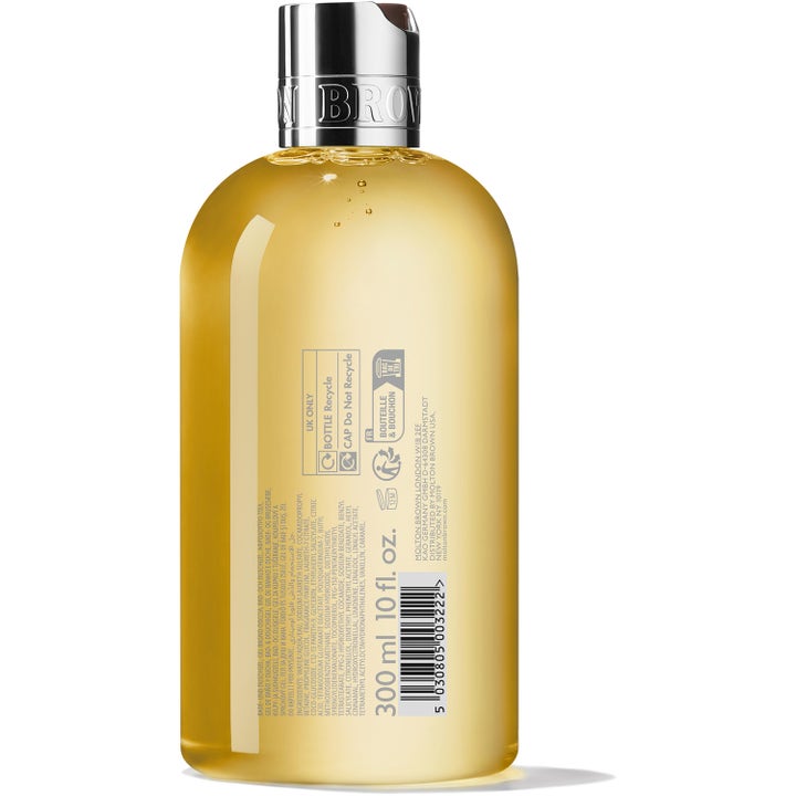 Molton Brown Flora Luminare Bath & Shower Gel 300 ml gir glød i en klar flaske som viser baksiden av etiketten