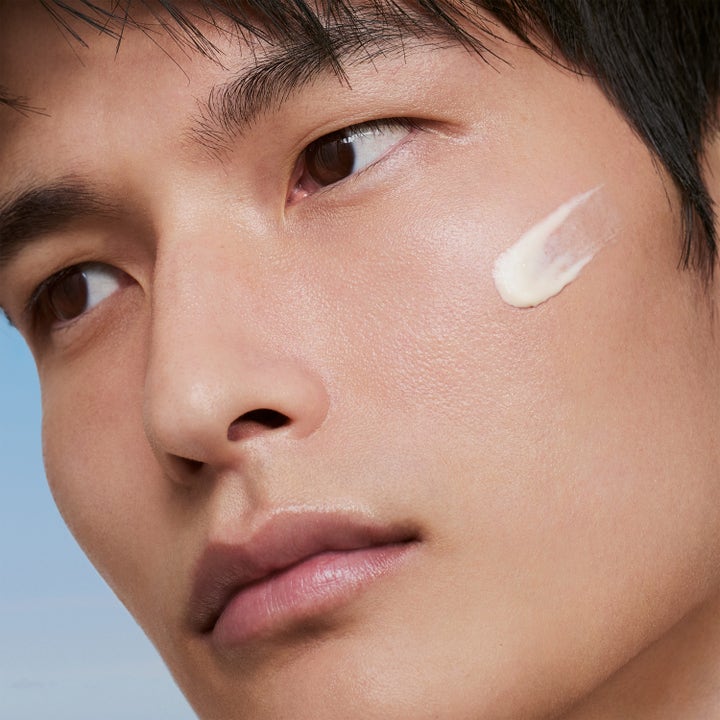 Lancaster Sun Perfect AIR Daily Invisible Fluid 40 ml solkrem ansikt SPF 50 påført som en hvit stripe på mannens kinn
