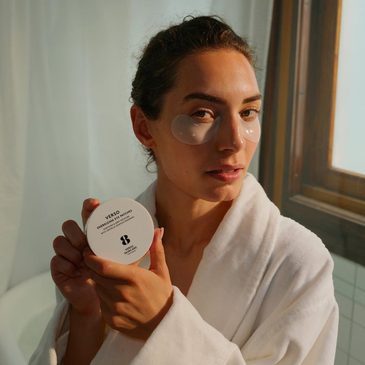 Verso N°8 Energizing Eye Patches 30 stk fuktighetsgivende øyeplaster vist på kvinne i badekåpe med hvit krukke
