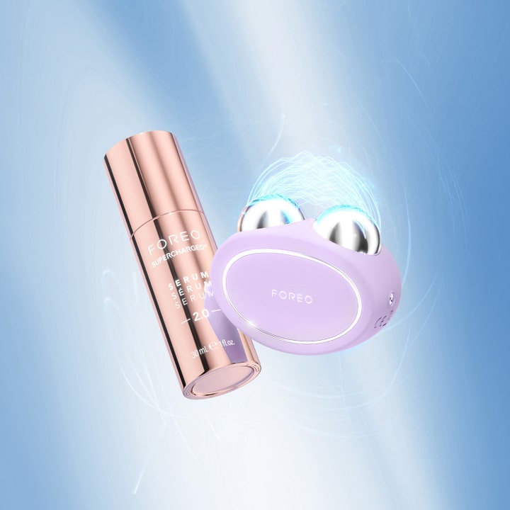 FOREO BEAR 2 Lavender 1 stk ansiktsløftende beauty tech med lilla enhet og rosegull serum på blå bakgrunn.