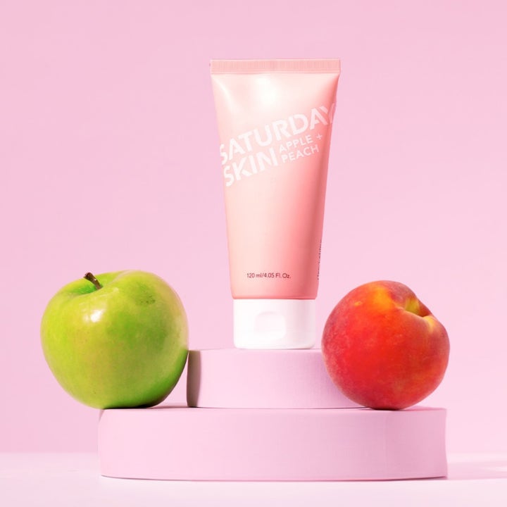 Saturday Skin Rise + Shine Gentle Cleanser 120 ml mild rens som gir glød i rosa tube med et grønt eple og en fersken