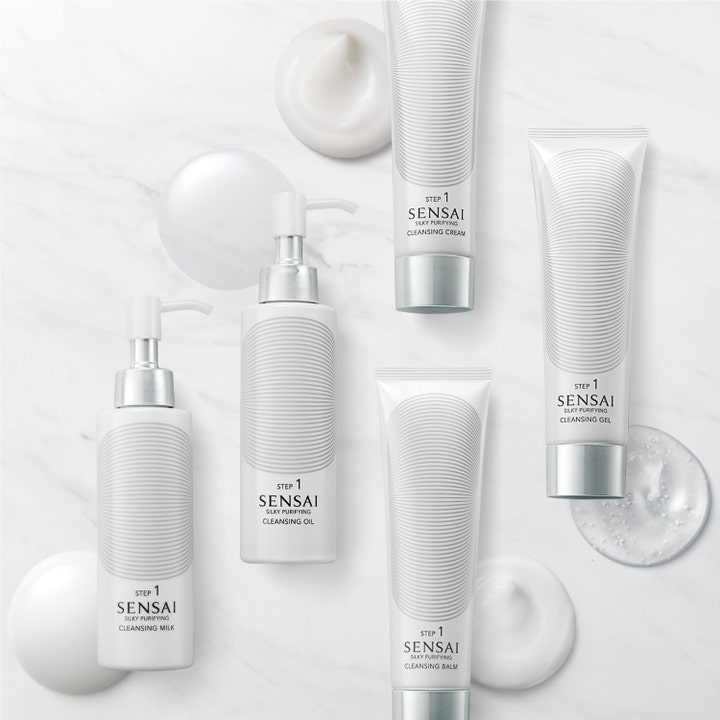 Sensai Silky Purifying Cleansing Milk 150 ml ansiktsrens med ulike teksturer på hvit marmorflate