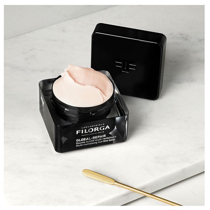 Filorga Global-Repair Balm 50 ml er en nærende ansiktskrem med fyldig rosa tekstur i en elegant sort krukke.