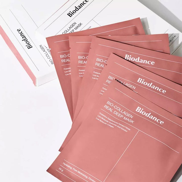 Biodance Bio Collagen-Real Deep Mask 34 g fuktighetsgivende ansiktsmaske i rosa poser ved siden av hvit eske.