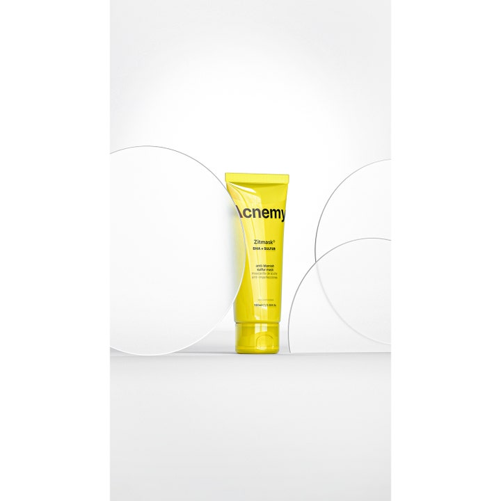 Niche Beauty Lab Acnemy Zitmask 100 ml ansiktsmaske med BHA og svovel i gul tube bak glassplater