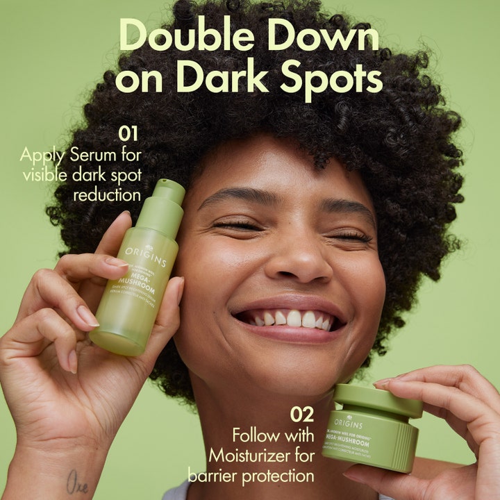 Origins Mega-Mushroom Dark Spot Brightening Moisturizer 50 ml ansiktskrem i krukke holdt av smilende kvinne