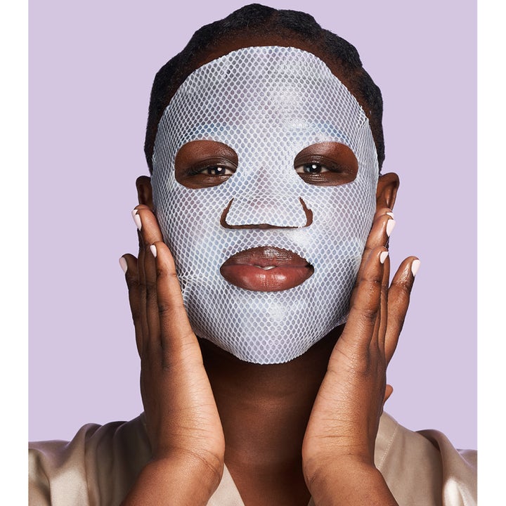 Exuviance Pick-Me-Up Plumping Mask 20 g sheet mask gir fuktighet vist på en kvinne med hvit mesh-maske.