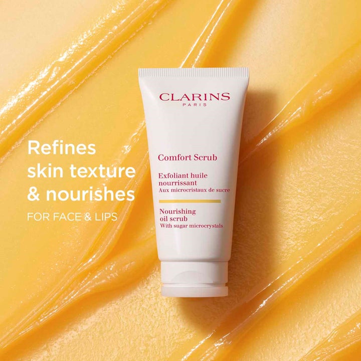Clarins Comfort Scrub 50 ml ansiktsskrubb gir næring hvit tube på en fyldig gul geltekstur med sukkerkrystaller