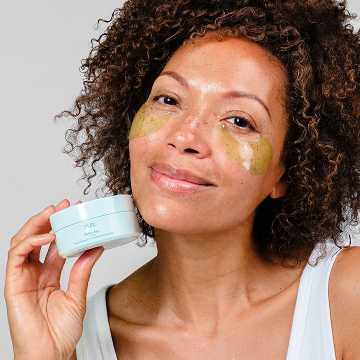 PÜR Mellow Eyes Rejuvenating Eye Patches 90 g foryngende øyemaske på kvinne som holder en lyseblå krukke