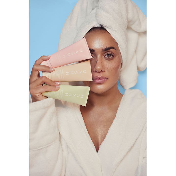 MASHH Pink Repair Moisture Mask 100 ml reparerende ansiktsmaske kvinne i hvit badekåpe holder tre fargede tuber