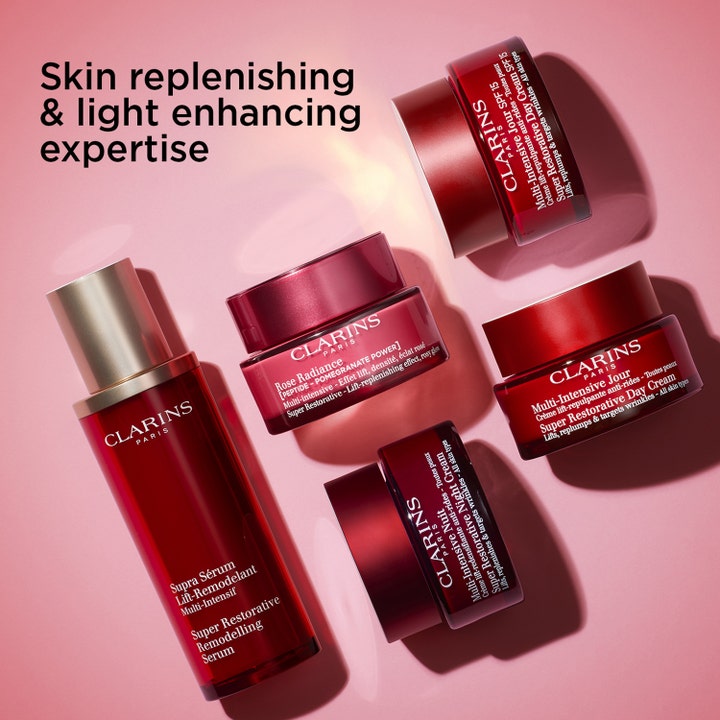 Clarins Rose Radiance Super Restorative 50 ml glødgivende anti age dagkrem i røde glasskrukker på rosa bakgrunn.