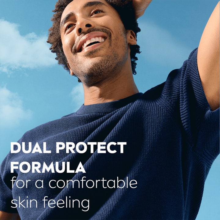 NIVEA Dry Impact Spray Deospray 150 ml herrdeodorant med Dual Protect Formula vist med en smilende mann ute.