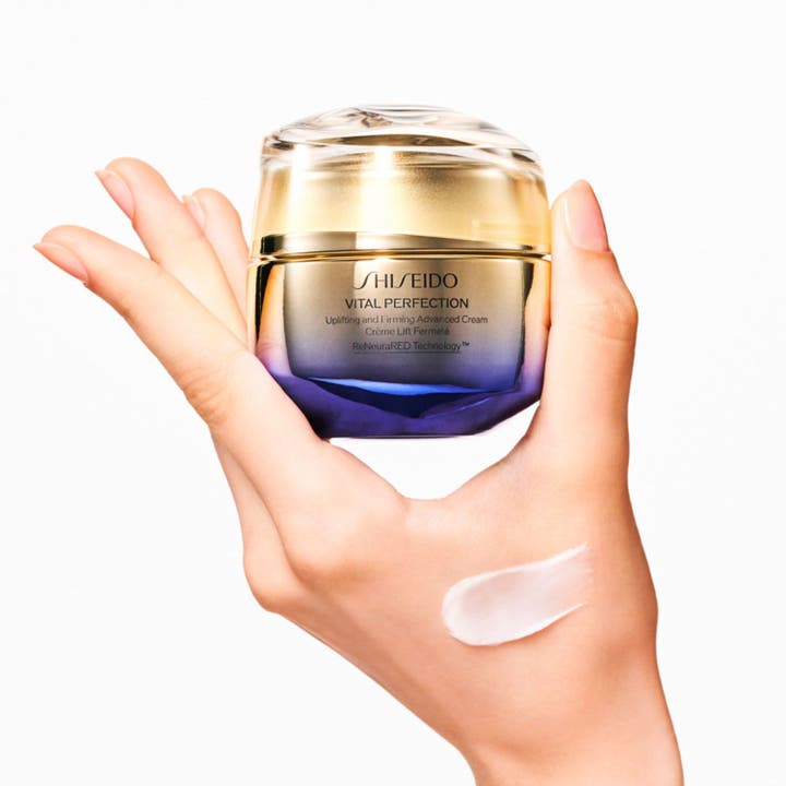 Shiseido Vital Perfection Advanced Day Cream 50 ml i luksuriøs krukke holdes i en hånd med kremet tekstur på huden