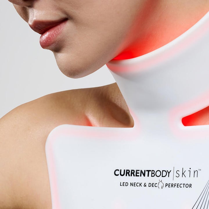 Currentbody Skin Neck and Dec Perfector LED-maske i hvit silikon som gir fastere hud med rødt lys på brystet