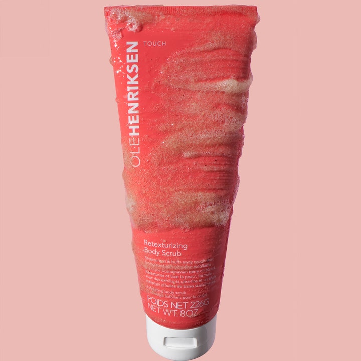 Ole Henriksen Touch Retexturizing Body Scrub Jumbo 240 g utjevnende kroppsskrubb i rosa tube dekket med kornete tekstur.