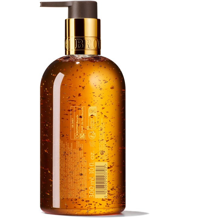 Molton Brown Mesmerising Oudh Accord & Gold 300 ml håndsåpe med gullspon i ravgul gel viser flaskens bakside og etikett.