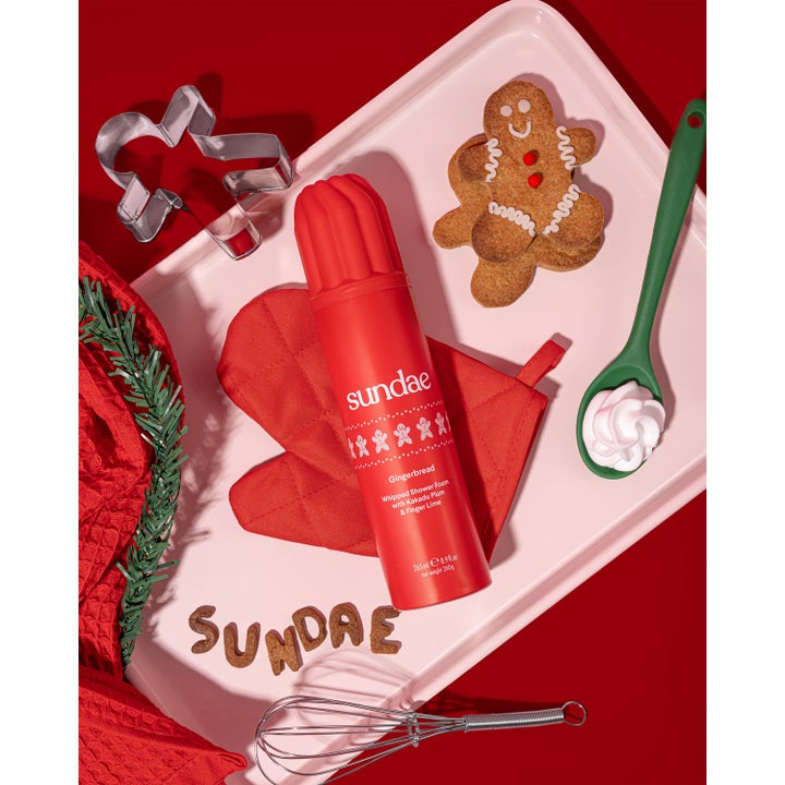 Sundae Whipped Shower Foam Gingerbread 265 ml dusjsåpe i rød sprayflaske på et brett med pepperkaker