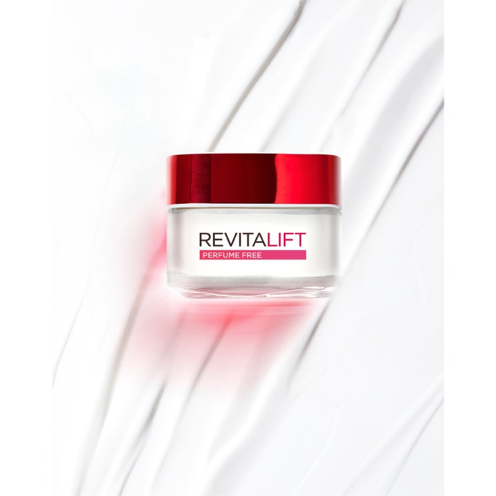L'Oréal Paris Revitalift 50 ml fuktighetsgivende ansiktskrem i hvit glasskrukke med rødt metallokk på kremet bakgrunn