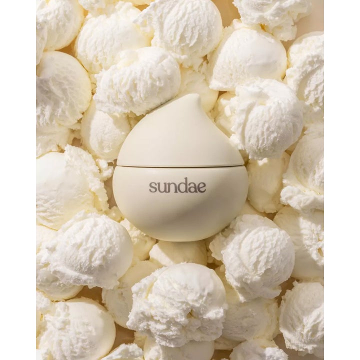 Sundae Whipped Body Moisturiser Velvety Vanilla 220 ml i dråpeformet krukke omgitt av hvit iskrem