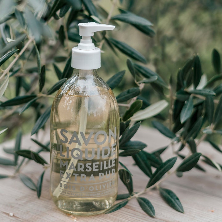 Compagnie de Provence Liquid Marseille Soap Olive Wood 495 ml mild håndsåpe i glassflaske med hvit pumpe og olivenblader.