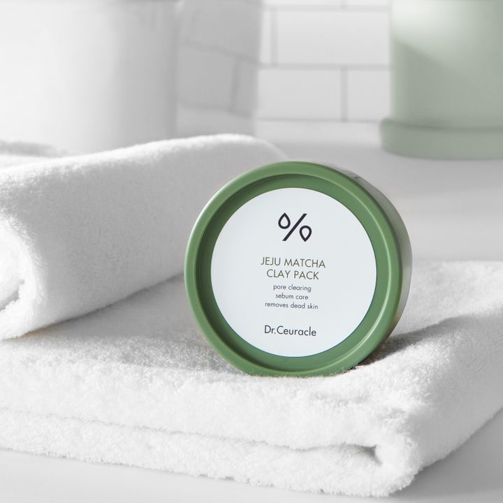 Dr. Ceuracle Jeju Matcha Clay Mask 115 g porensensende ansiktsmaske i grønn krukke på et hvitt håndkle