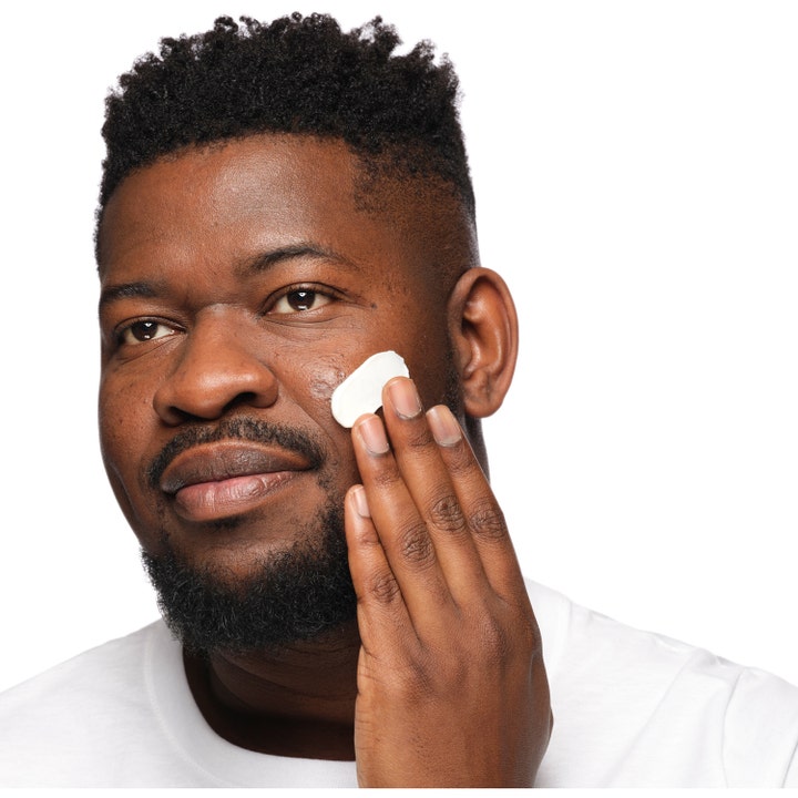 The Ordinary Natural Moisturizing Factors + Phytoceramides 30 ml fuktighetskrem som en mann påfører på kinnet.