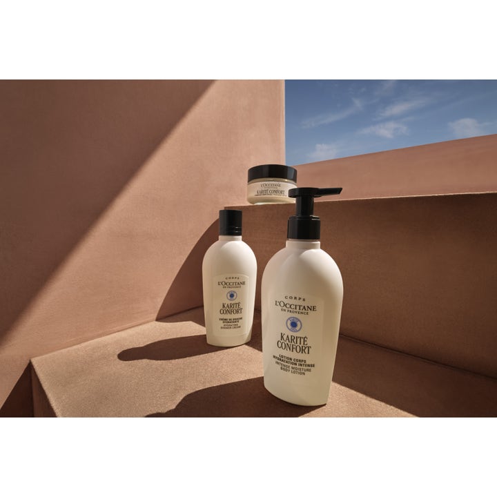 L'Occitane en Provence Shea Butter Body Lotion 240 ml fuktighetskrem i hvit pumpeflaske mot varm terracotta-bakgrunn