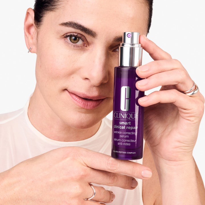 Clinique Smart Clinical Repair Serum 75 ml lilla hudserum mot rynker i flaske med sølvpumpe holdt av en kvinne