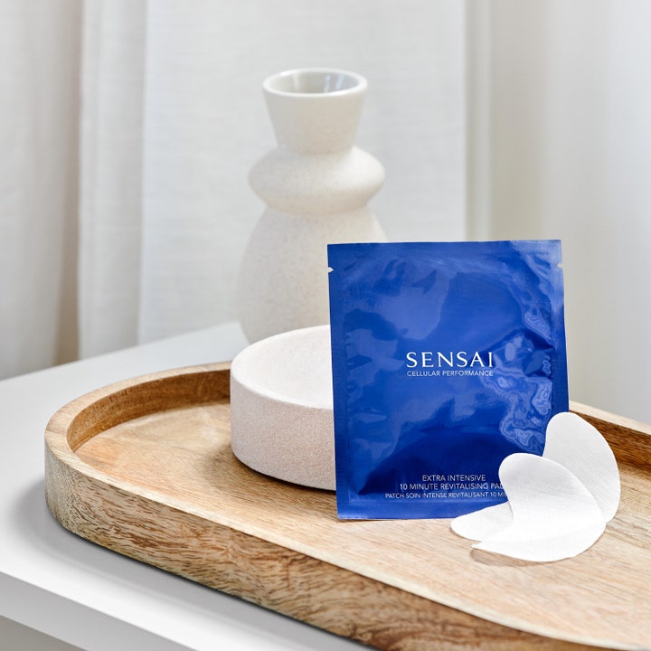 Sensai Cellular Performance Revitalizing Pads 60 g fuktighetsgivende eye patches i blå pose på et trefat