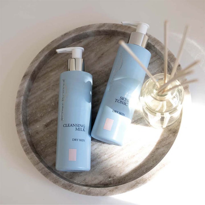 Beauté Pacifique Cleansing Milk og Skin Tonic for tørr hud i lyseblå pumpeflasker på et grått marmorbrett.