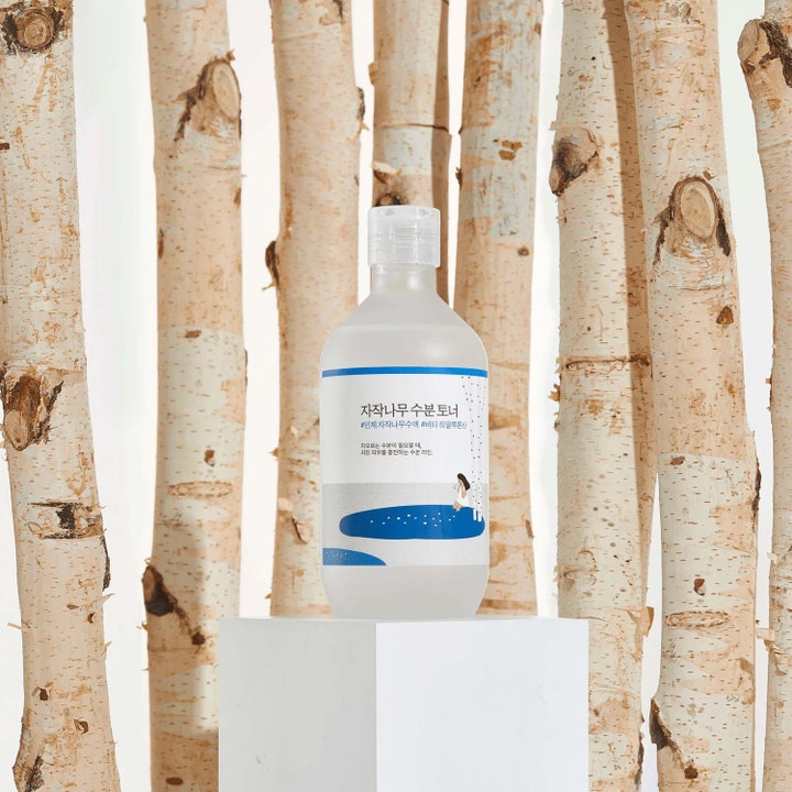 Round Lab Birch Juice Moisturizing Toner 300 ml fuktighetsgivende ansiktsvann plassert mellom bjørketrær