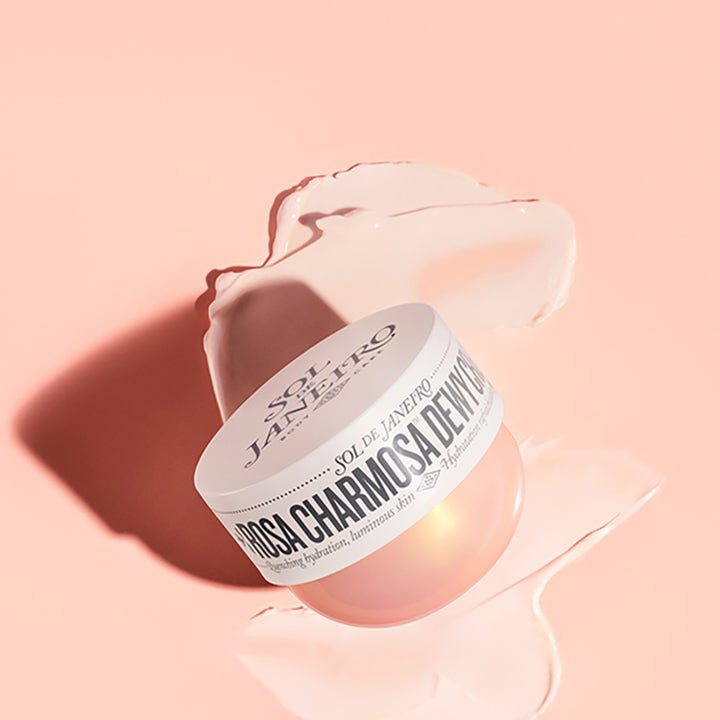 Sol de Janeiro Rosa Charmosa Dewy Cream 75 ml fuktighetsgivende kroppskrem i krukke omgitt av fyldig rosa tekstur.