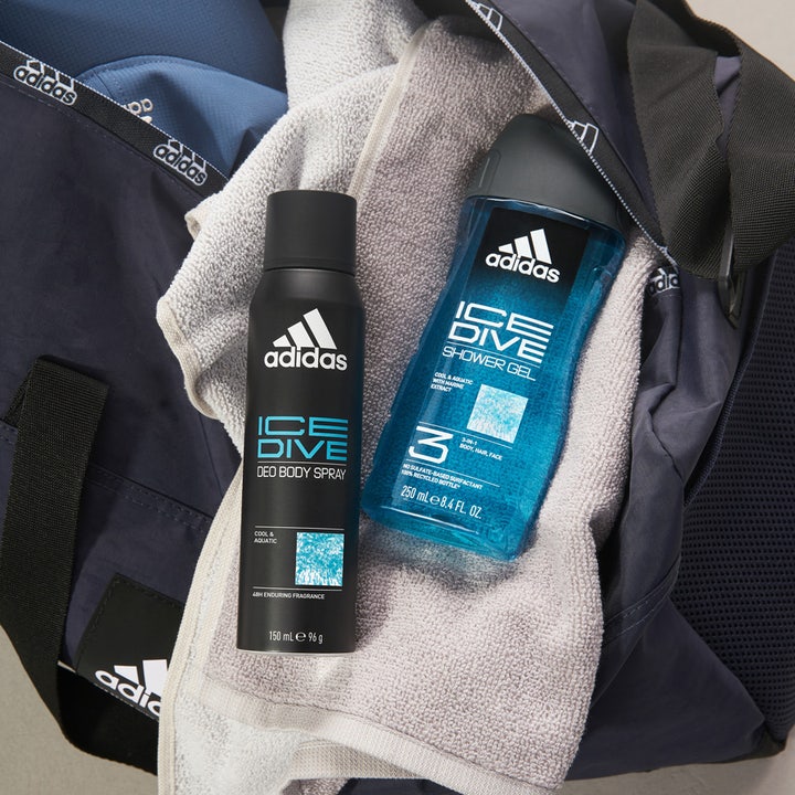 Adidas Ice Dive For Him Shower Gel 400 ml frisk dusjsåpe ved siden av deospray i en mørkeblå treningsbag.