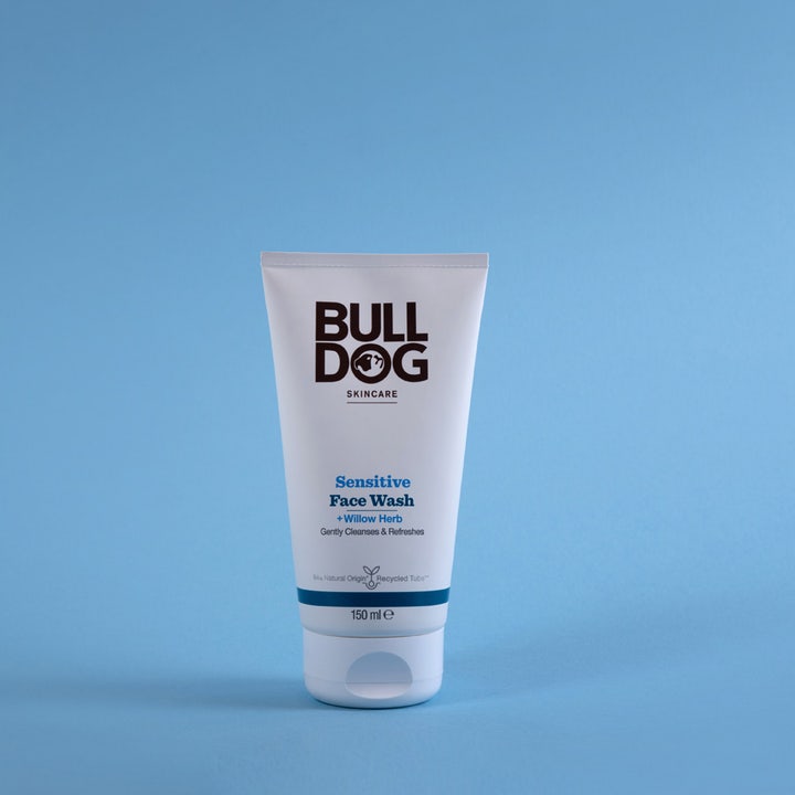 Bulldog Sensitive Face Wash 150 ml ansiktsrens med beroligende geitrams i hvit tube mot blå bakgrunn.