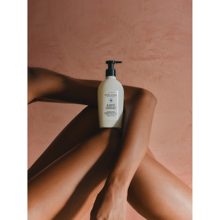 L'Occitane en Provence Shea Butter Body Lotion 240 ml fuktighetsgivende krem på hvit pumpeflaske mot bare ben.