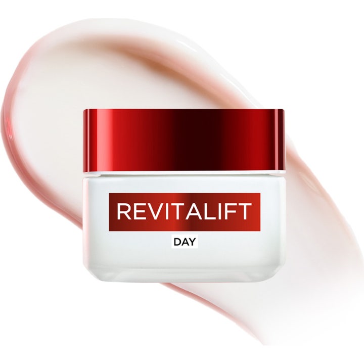 L'Oréal Paris Revitalift Day Cream 50 ml dagkrem i hvit krukke med rødt lokk mot en fyldig kremtekstur