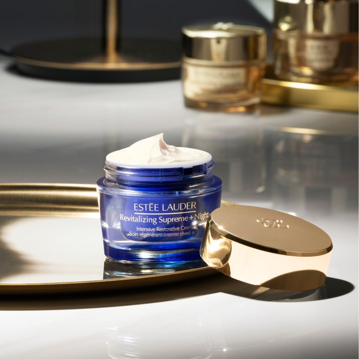 Estée Lauder Revitalizing Supreme + Night 50 ml nattkrem i åpen blå glasskrukke med hvit kremtekstur og gullokk.