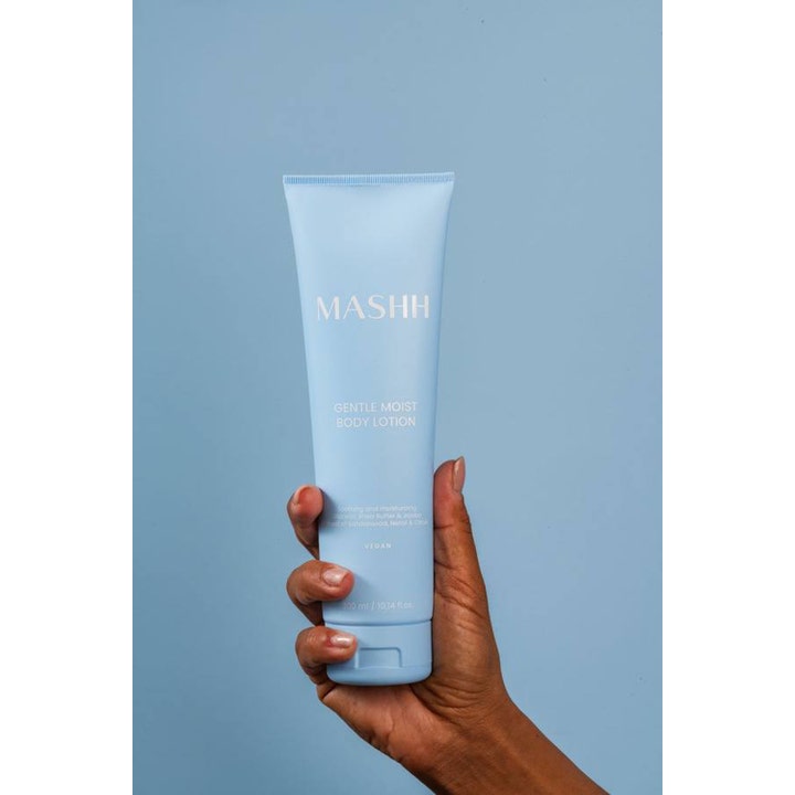 MASHH Gentle Moist Body Lotion 300 ml fuktighetsgivende krem i lyseblå tube holdes av en hånd