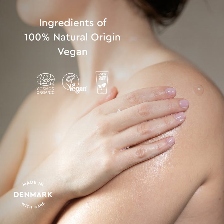 Urtekram Nordic Berry Creamy Body Wash 200 ml vegansk dusjsåpe påføres huden med tekst om 100% naturlig opprinnelse.