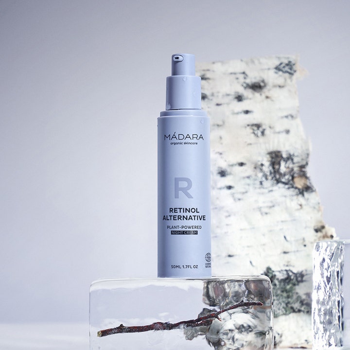 MÁDARA RETINOL ALTERNATIVE 50 ml nattkrem i lilla pumpeflaske på en isblokk med dekorativ bjørkebark bak.