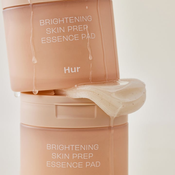 House of Hur Brightening Skin Prep Essence Pad 140 ml gir glød med fuktige pads mellom to ferskenfargede krukker.