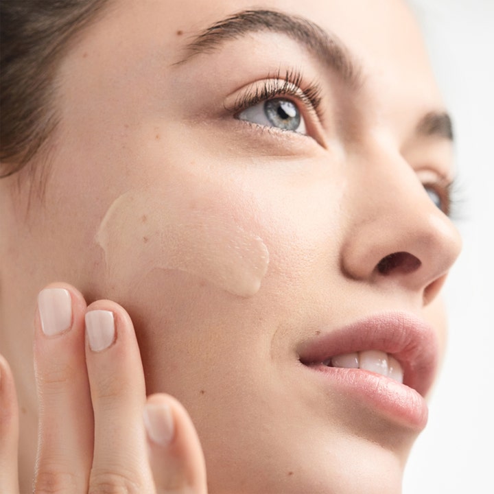 Clinique Dramatically Different Moisturizing Lotion + 125 ml fuktighetskrem kvinne påfører gul krem på kinnet