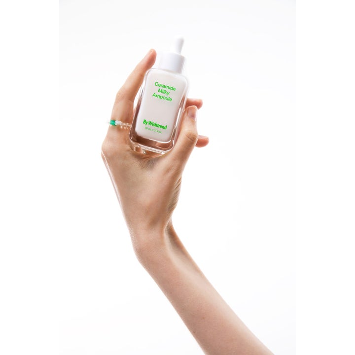 By Wishtrend Cera-barrier Soothing Ampoule 30 ml beroligende serum i glassflaske holdt av en hånd