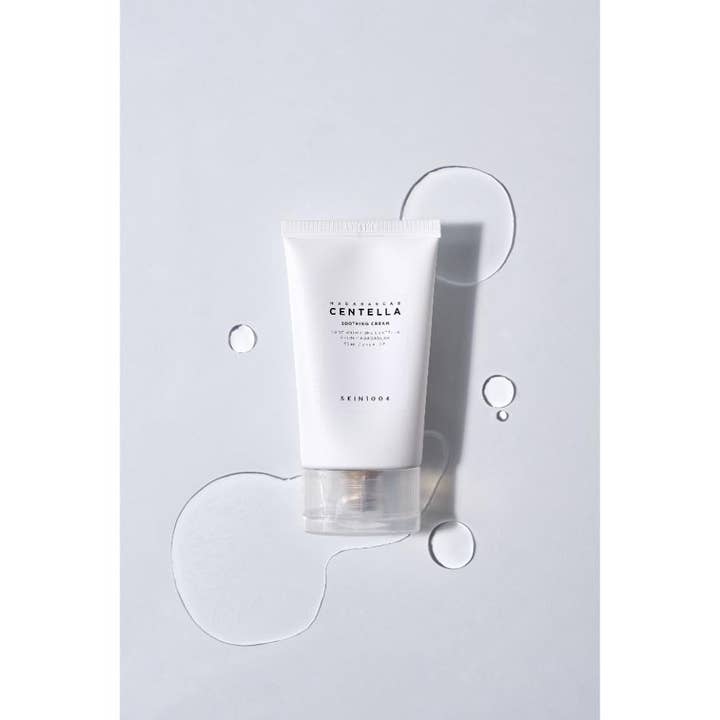 SKIN1004 Madagascar Centella Soothing Cream 75 ml beroligende ansiktskrem i hvit tube omgitt av klare vanndråper