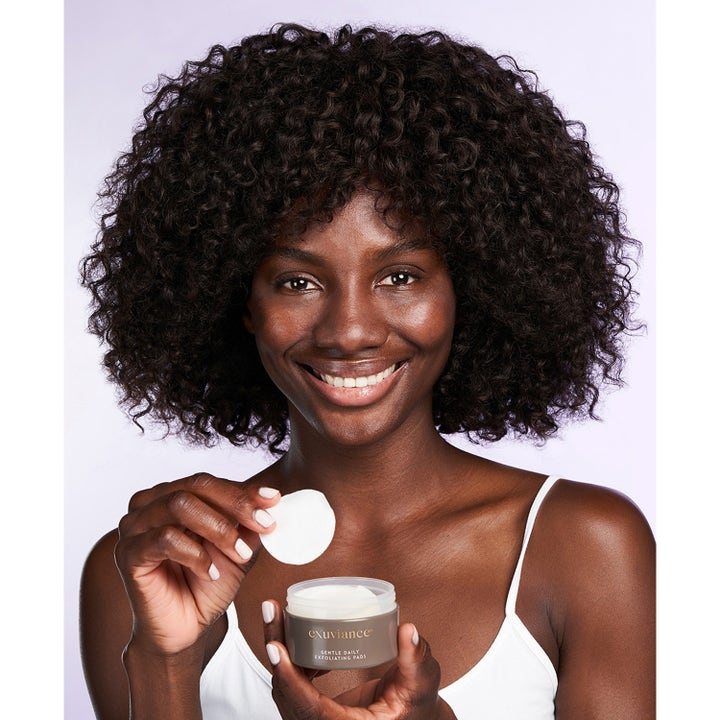 Exuviance Gentle Daily Exfoliating 60 Pads hudpleie brukes av smilende kvinne for en glødende hud