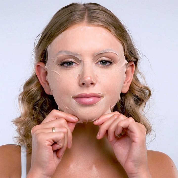 Starskin 100% Camellia 2-Step Oil Sheet Mask 25 g næringsgivende ansiktsmaske som her ses påført en kvinne.