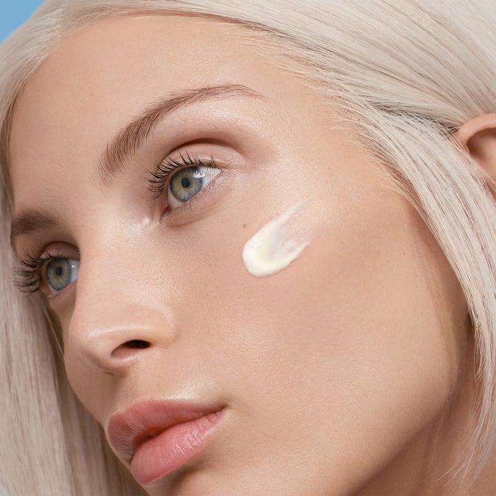 Lancaster Sun Beauty Face & Body Cream 30 ml solkrem for ansiktet med hvit kremtekstur på en kvinnes kinn