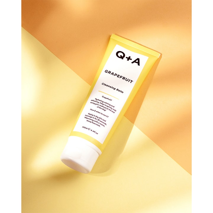 Q+A Grapefruit Cleansing Balm 125 ml fuktighetsgivende ansiktsrens i gul og hvit tube på stemningsfull gul bakgrunn.